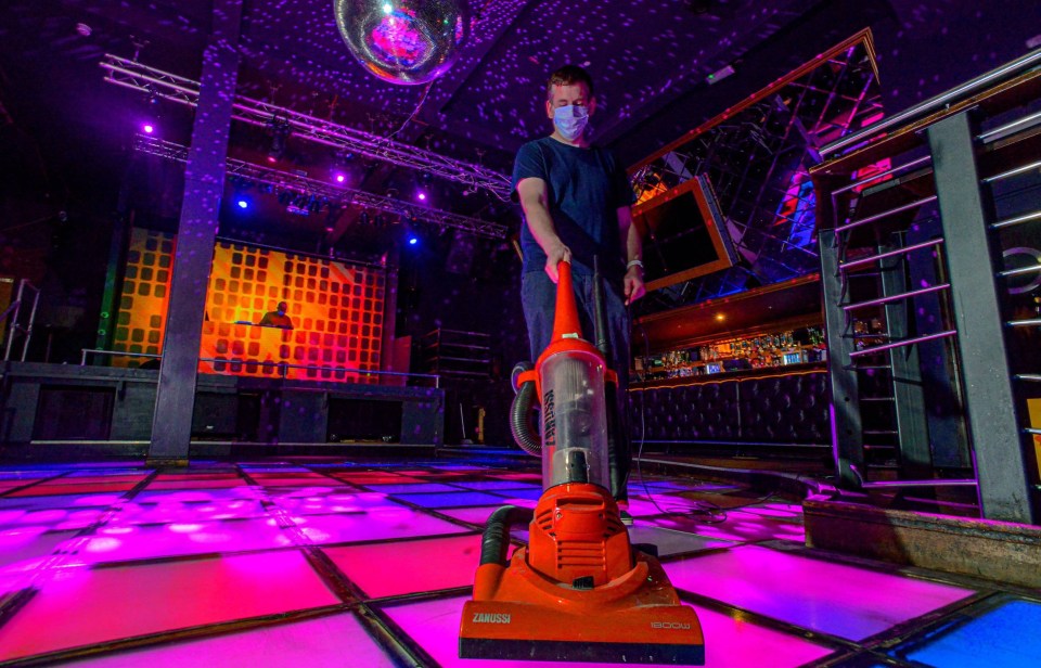 A cleaner vacuums the dancefloor ahead of the venue's grand reopening