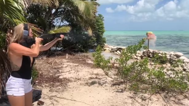 Jasime Hartin is filmed on a beach with a shotgun as she blasts a watermelon