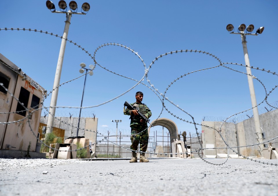 An Afghan National Army soldier stands guard at the gate of Bagram US air base