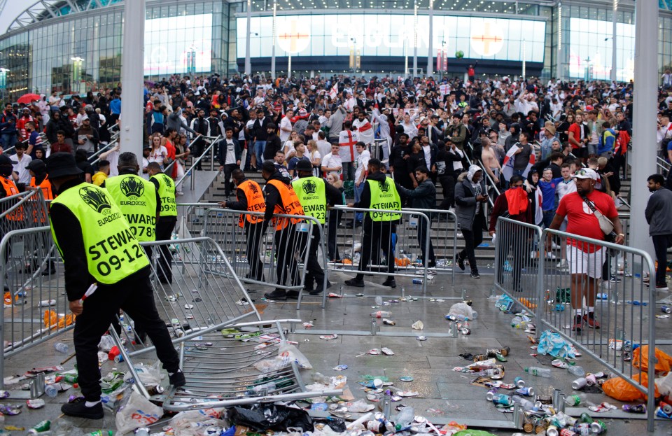 Stewards replace barricades after they were knocked over outside Wembley at the Euro final