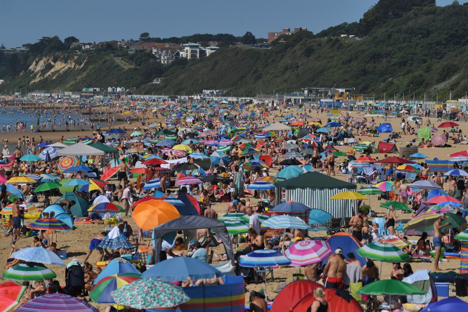 Sun seekers put up their beach parasols to protect themselves from the blistering heat