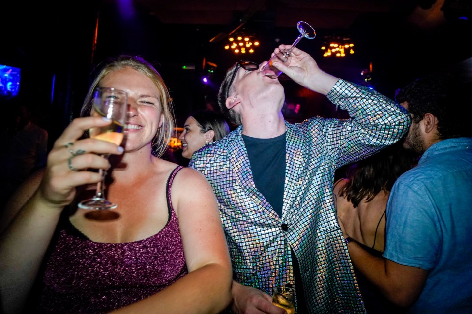 Partygoers in London's The Piano Works toast the reopening of England's nightclubs