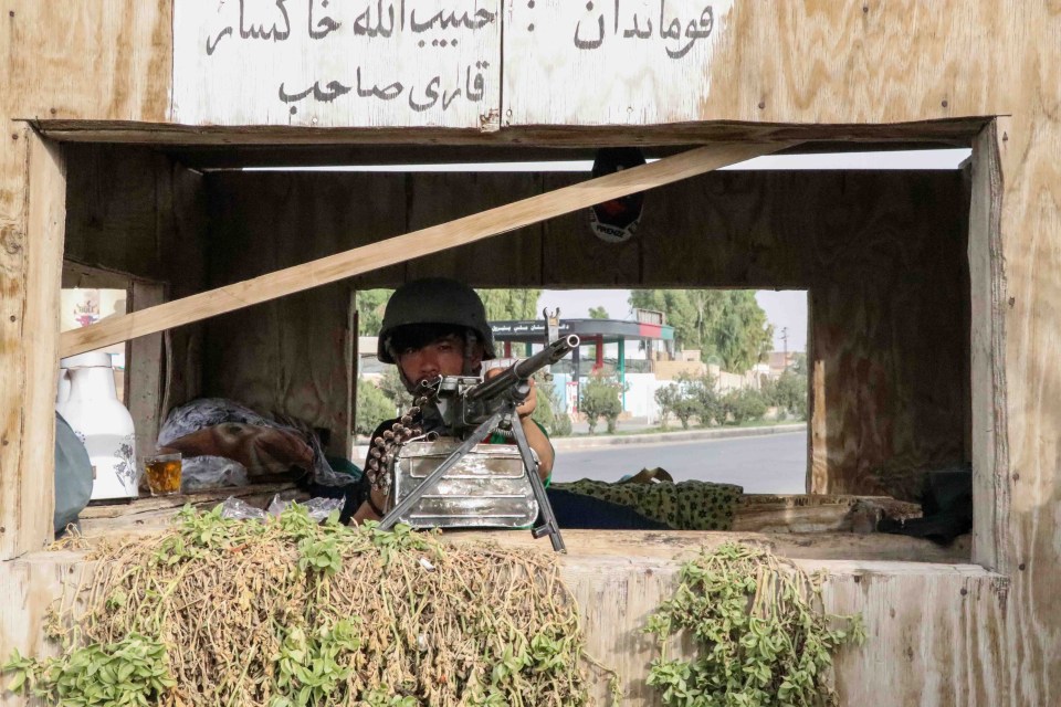 An Afghan security official stands alert at a checkpoint in Kandahar