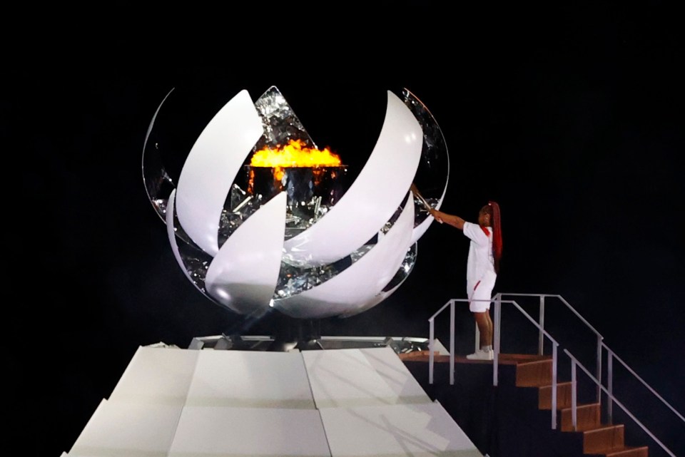 Naomi Osaka of Japan holds the Olympic torch after lighting the Olympic cauldron at the opening ceremony