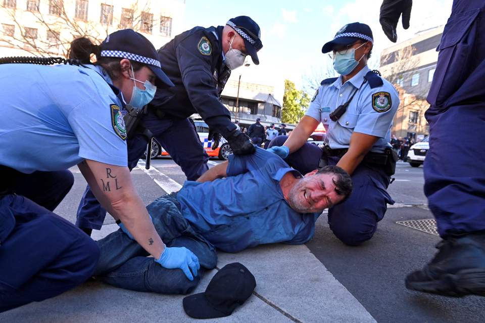 Police arrest a protester at a rally in Sydney on July 24