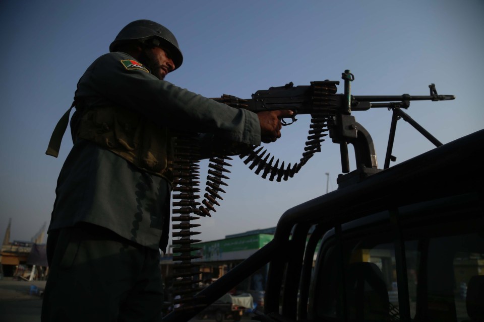 An Afghan security official stands guard at check point in Jalalabad