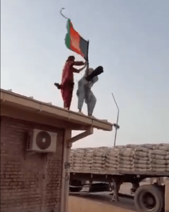 Taliban militants tear down the Afghan national flag at a border checkpoint in Islam Qala