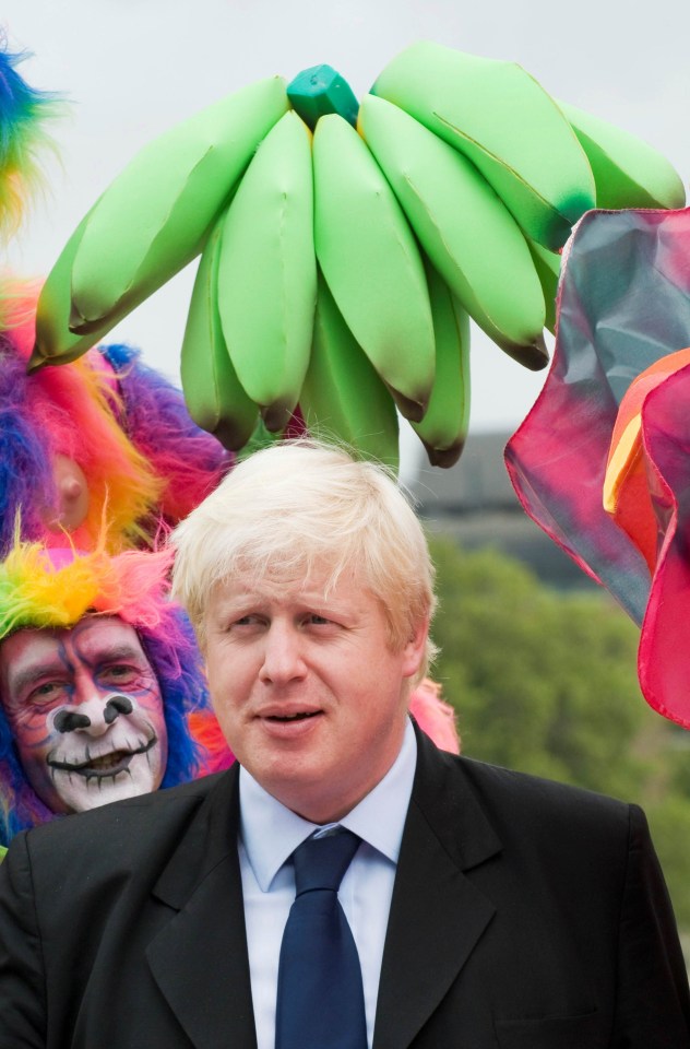 Boris Johnson posed while a mischievous 'monkey' swang a prop bunch of bananas over the mayor's head