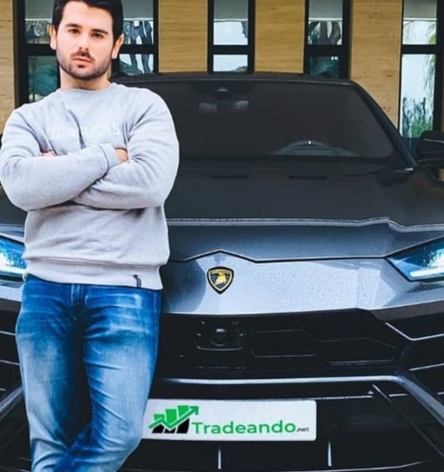 Enrique Moris posing with a sports car