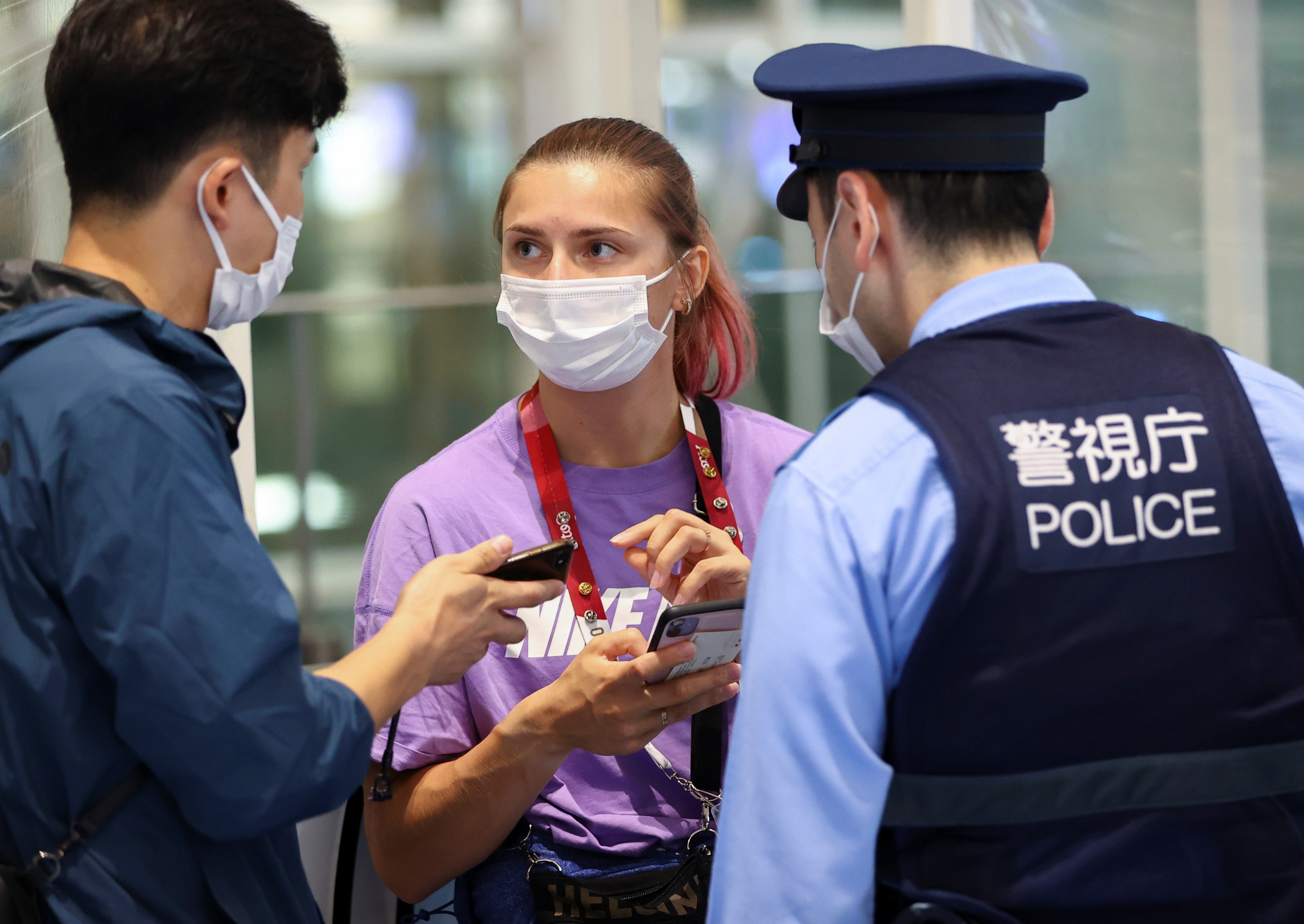 Belarusian athlete Krystsina Tsimanouskaya talks with a police officer at Haneda international airport in Tokyo, Japan