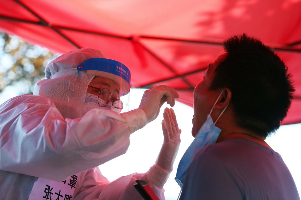 A medical worker takes a swab sample in Zhengzhou, central China's Henan Province