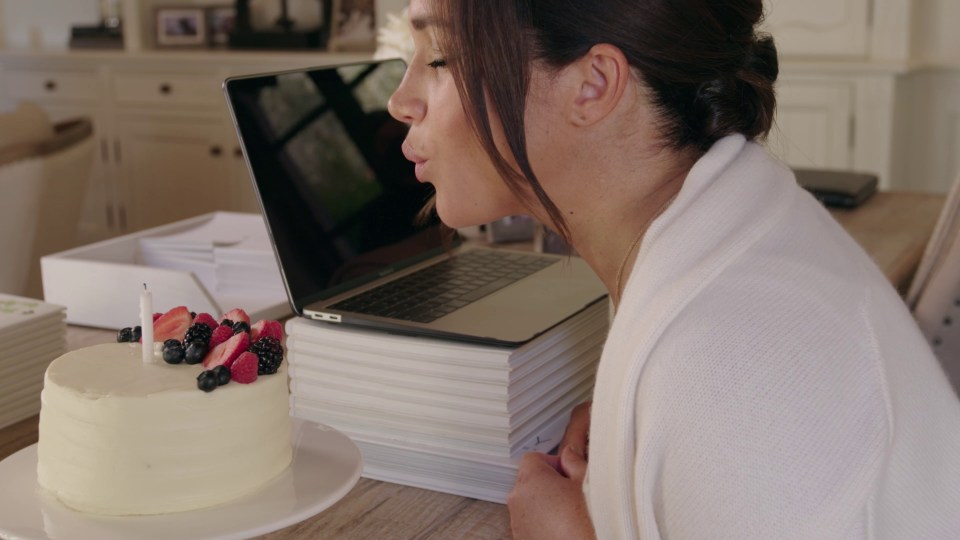 The Duchess of Sussex blowing out a candle on a cake during the video