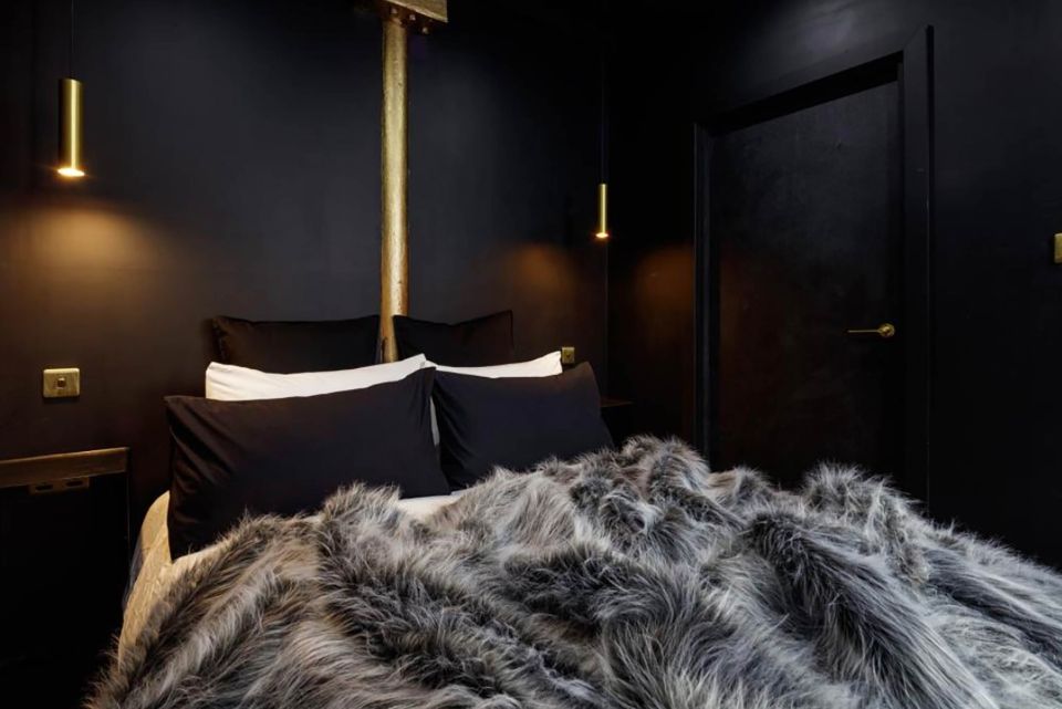 The luxurious bed covers and sheets are also black and gothic