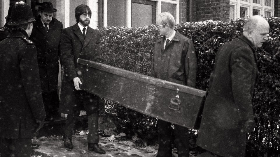 Officers carry out a coffin from one of the addresses