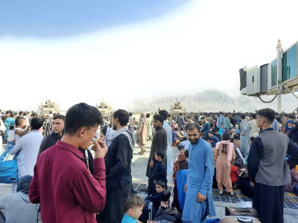 Afghans crowd at the tarmac of the Kabul airport