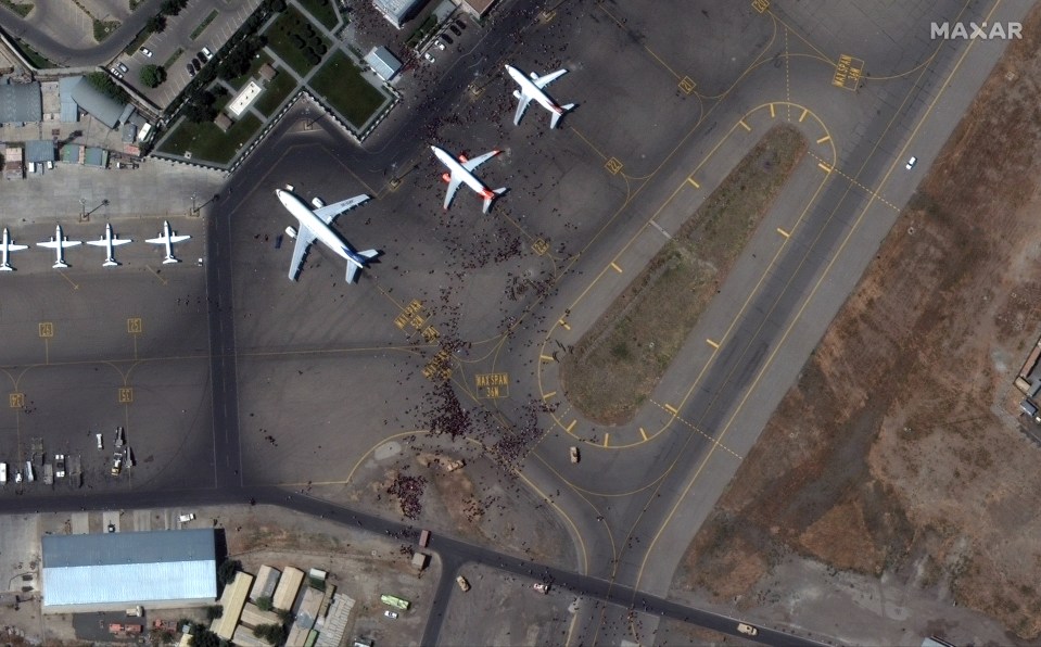 Planes waiting to take off as crowds of people storm the airport in Kabul