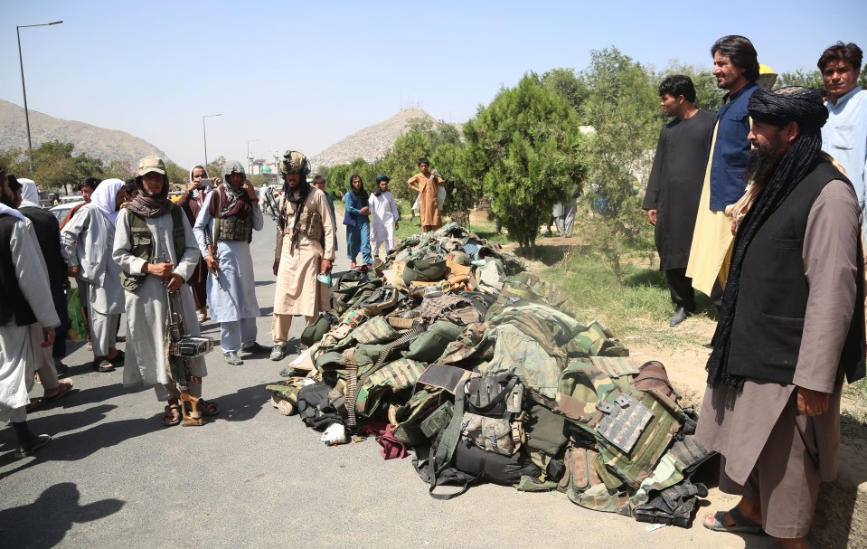 Taliban fighters gloat over piles of equipment abandoned by fleeing Afghan Army soldiers in Kabul