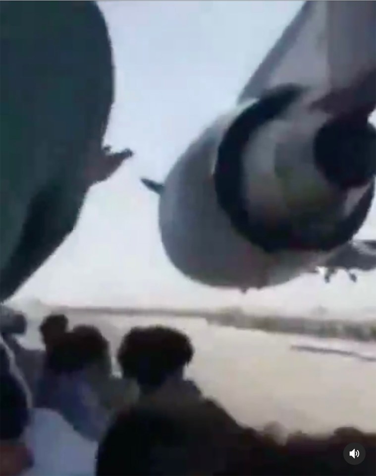 Footage showing men riding on the wheel bay of the plane