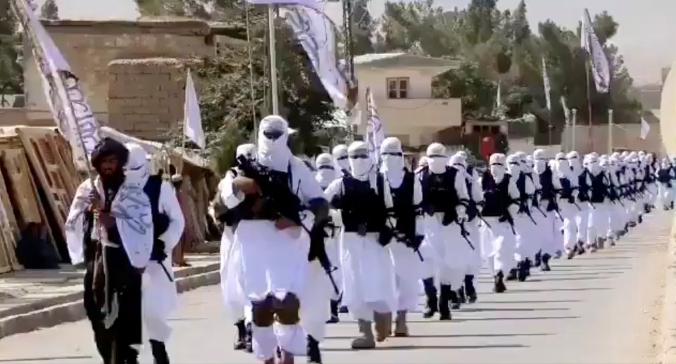 Taliban fighters put on a show of force in a procession through Qalat