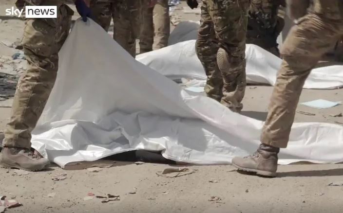 Troops lay covers over bodies following the crush