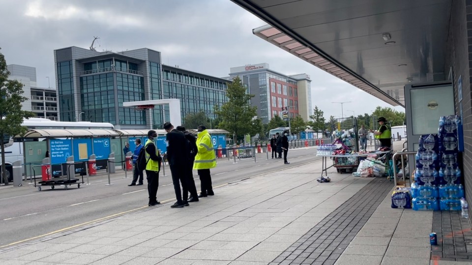 Police and other officials waiting outside the arrivals hall at Birmingham Airport, as refugees from Afghanistan arrive in England