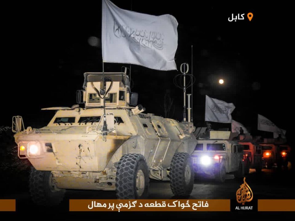 Taliban fighters with Humvees and armoured trucks flying their white flag