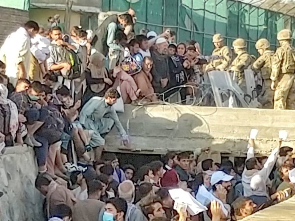 People waving their documents trying to catch the attention of soldiers