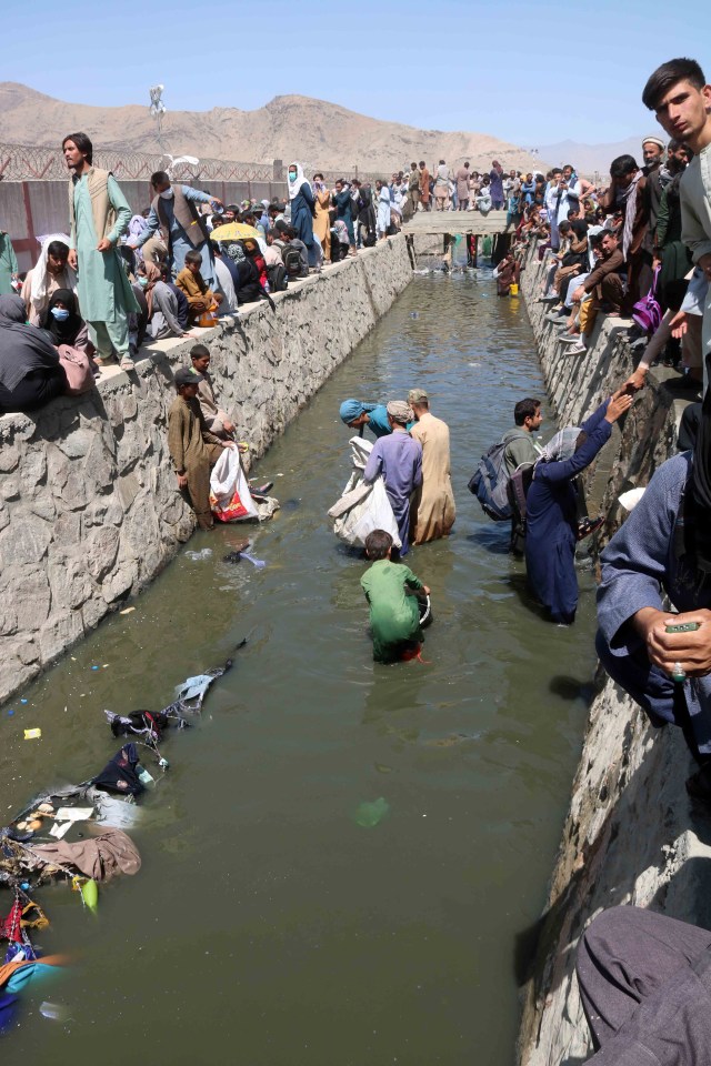 Desperate Afghans wade through sewage outside the airport