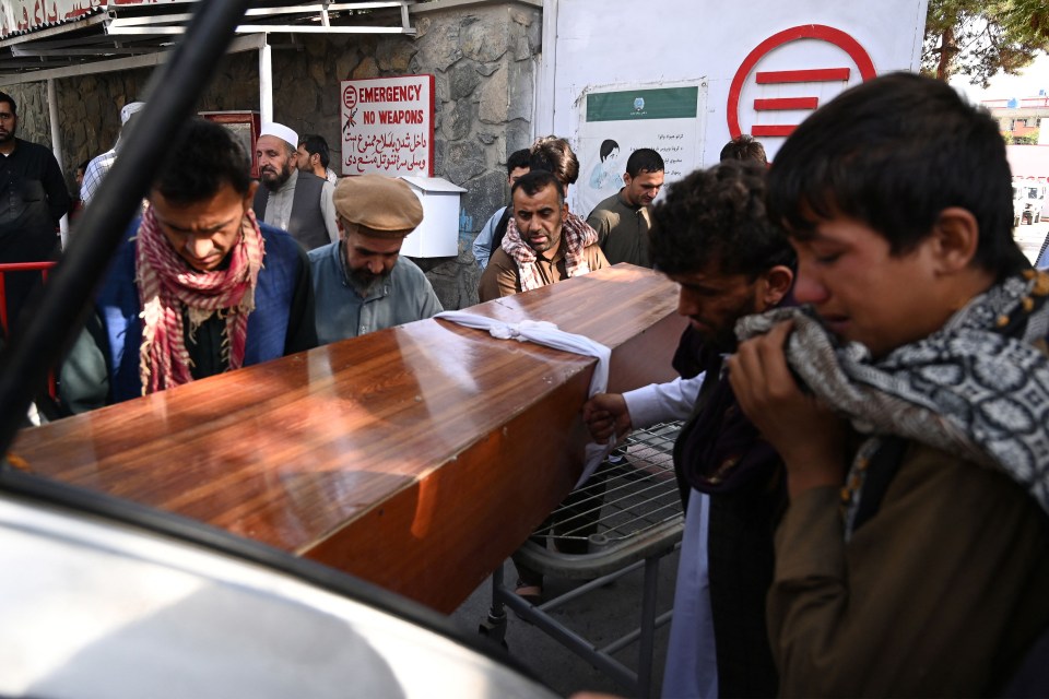 Relatives load a victim of Thursday’s bombings at Kabul airport into their car