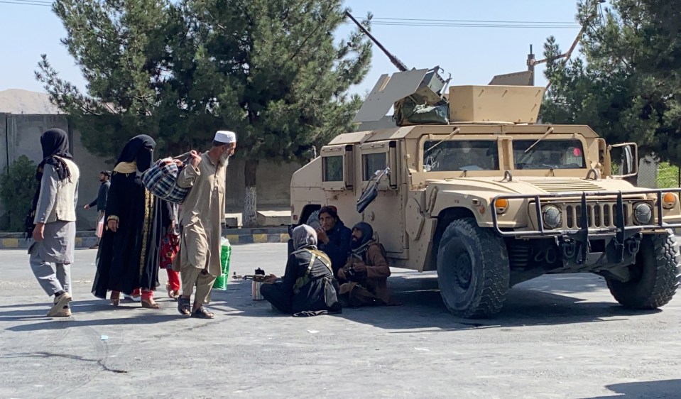 Taliban stand guard as they block the road to Hamid Karzai Airport a day after the deadly blast