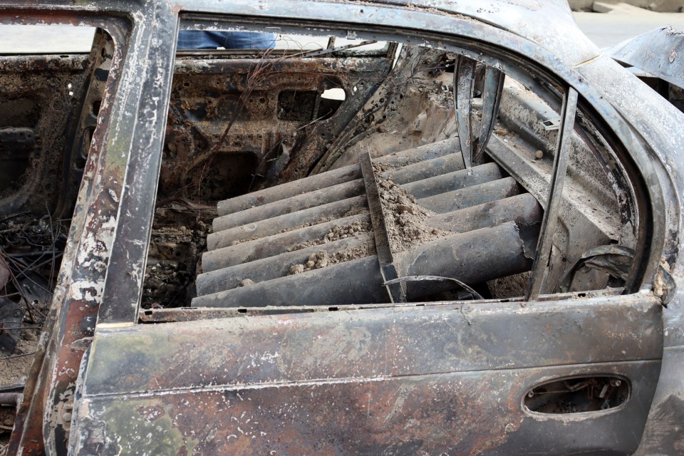 Rocket launcher tubes are seen in the wreckage of a car