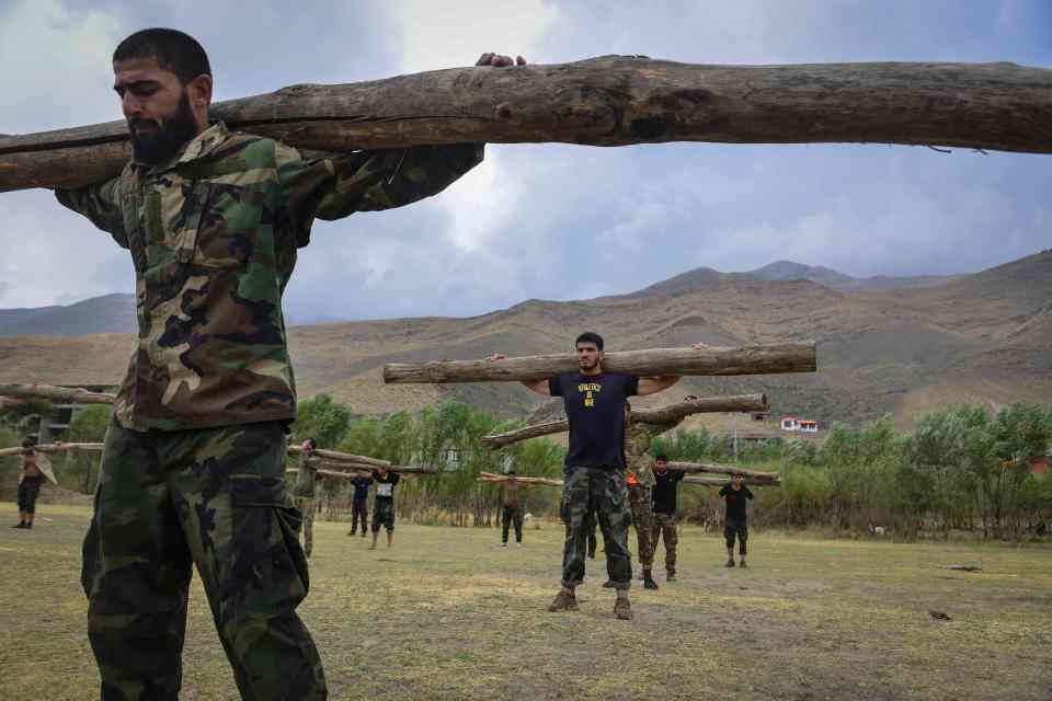 Resistance fighters were seen balancing heavy wooden logs on their shoulders