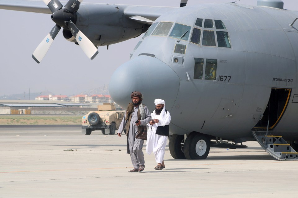 Taliban members keep guard of the Air Force aircraft