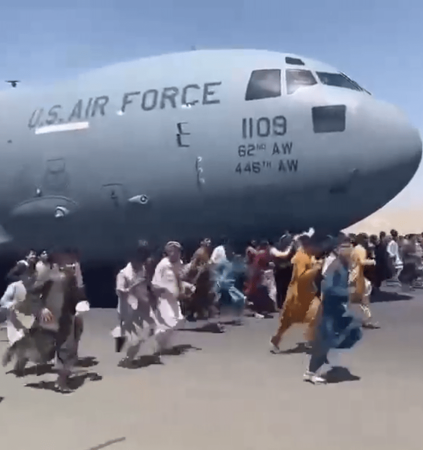 Afghans running along side the C-17 plane as it was preparing to take off