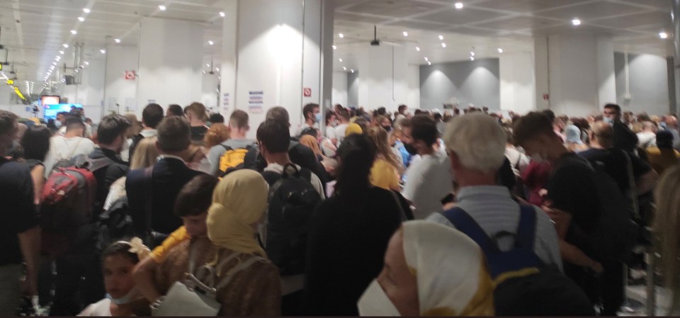 Footage shows the arrivals area packed with passengers trying to get out