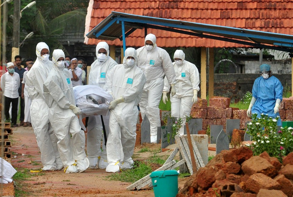 Doctors and relatives wearing protective gear carry the body of a victim during a Nipah virus outbreak in 2018 (STOCK)