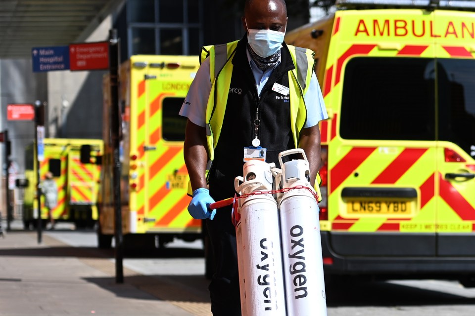 Hospital staff move oxygen tanks outside the Royal London hospital in London