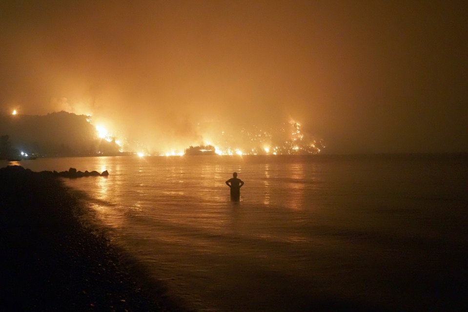 Mann has said the future could be dystopian, this is a picture of a person watching wild fires in Athens earlier this year