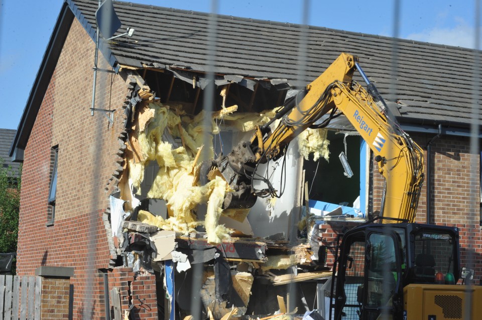 Roof tiles and insulation can be seen falling from the home