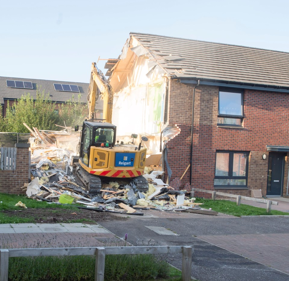 A digger was pictured tearing the wrecked house to the ground