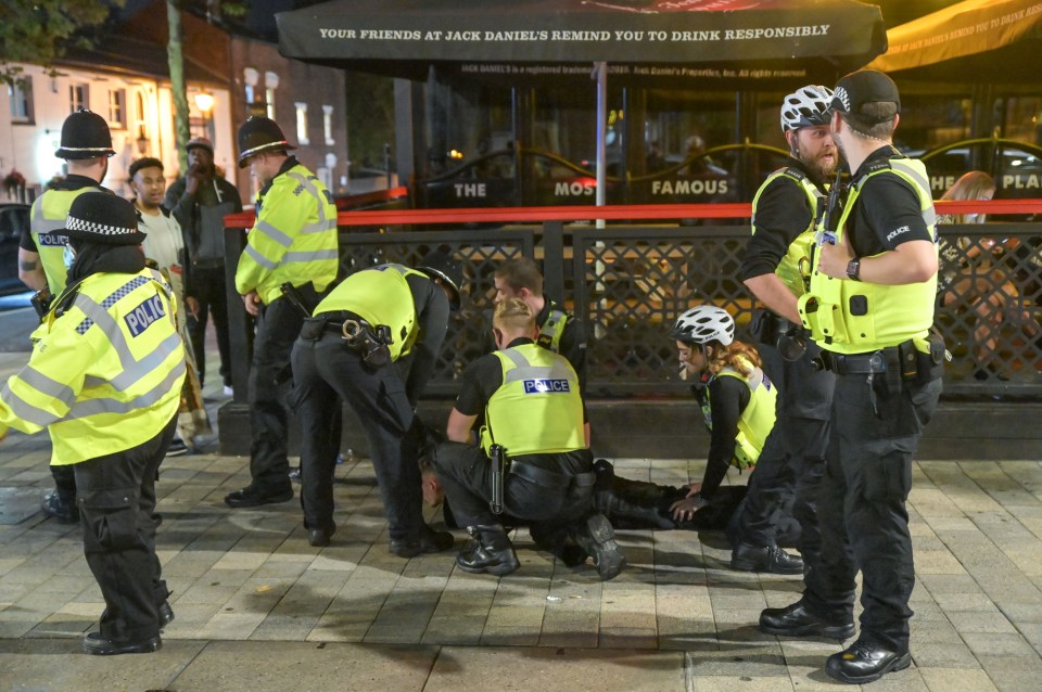 A man is restrained by several officers in Birmingham