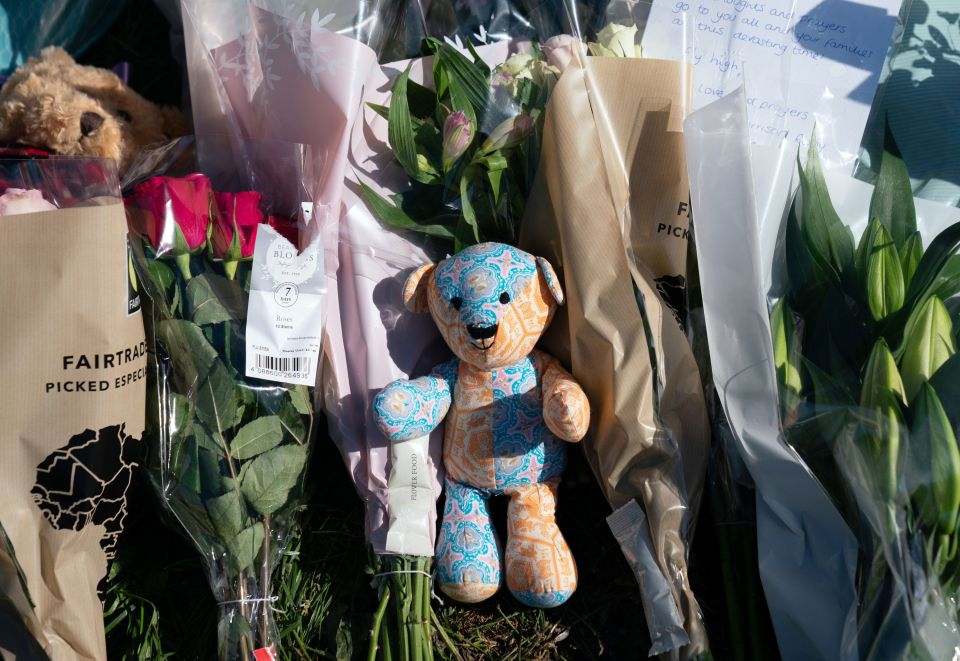 A teddy is left among tributes at the scene