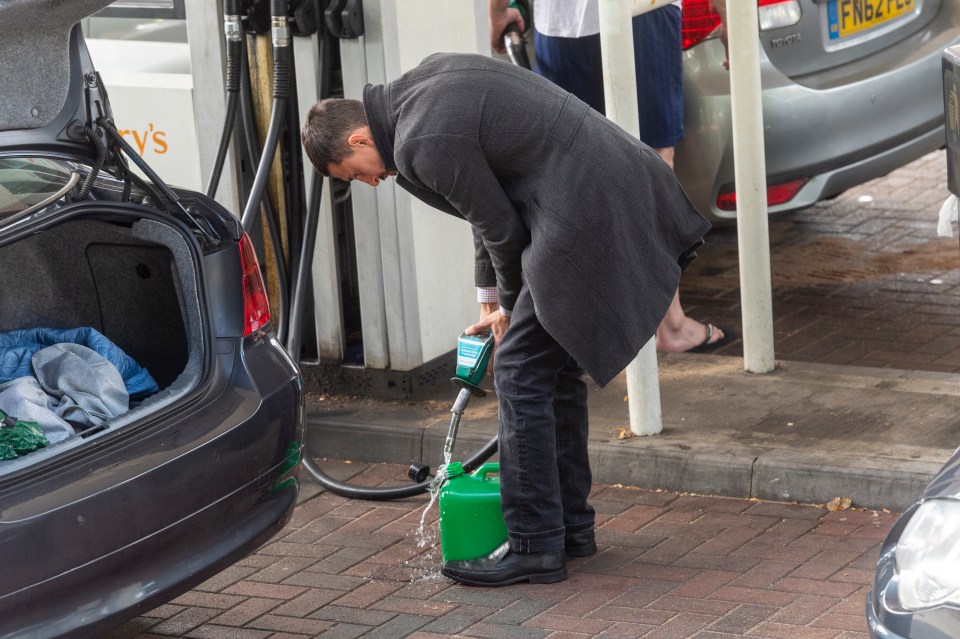 A driver filling up a jerry can with petrol in London