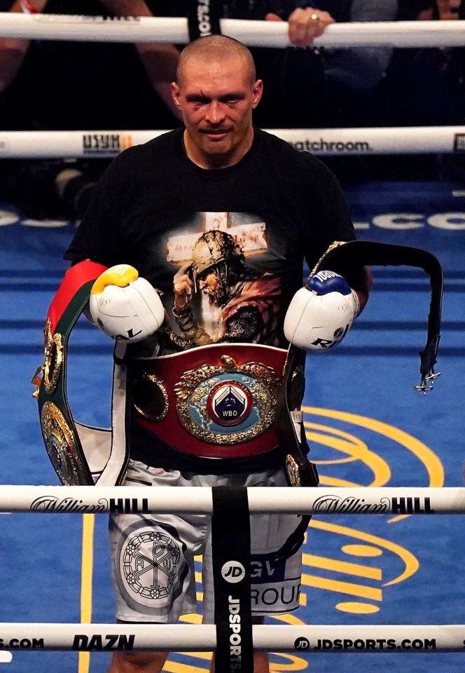 The new champ holds his belts inside the ring after the results come in