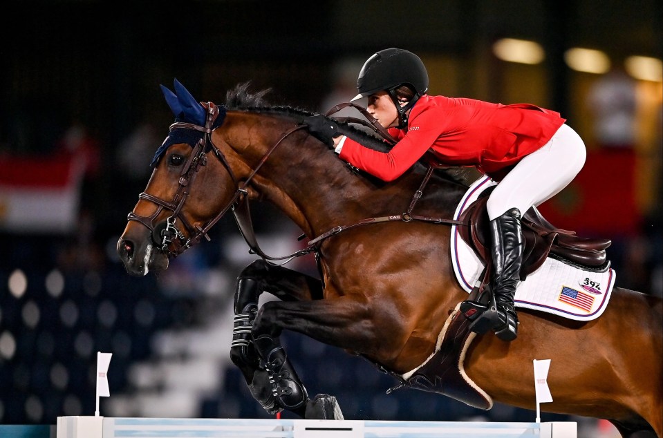 a woman in a red jacket is riding a brown horse