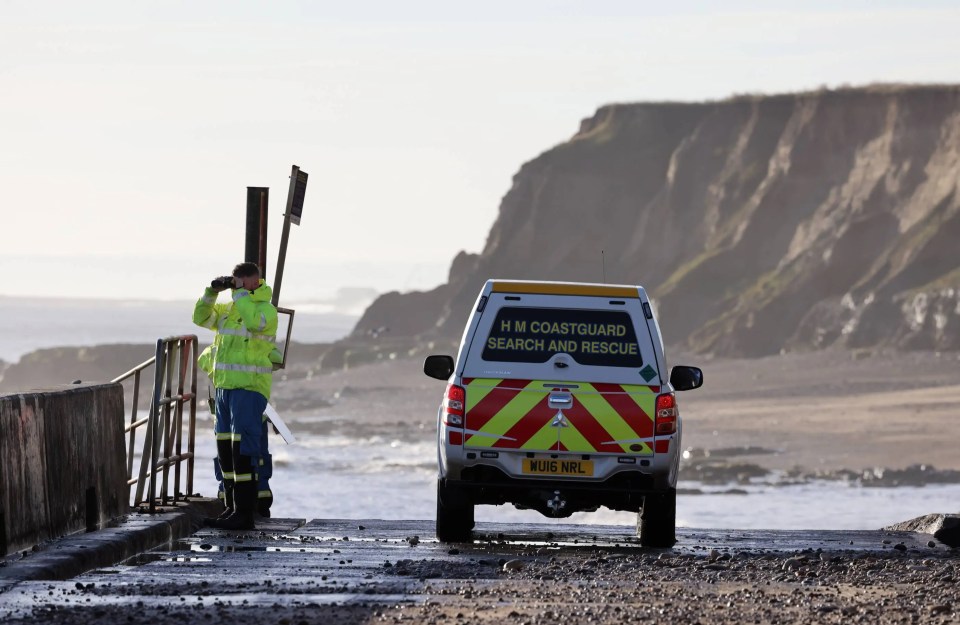 A coastguard looks out at Hendon Beach after a woman was swept away