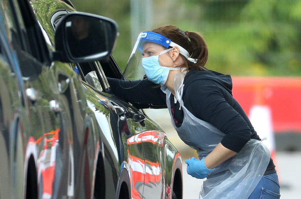 A medical worker takes a swab at a coronavirus drive-through testing centre