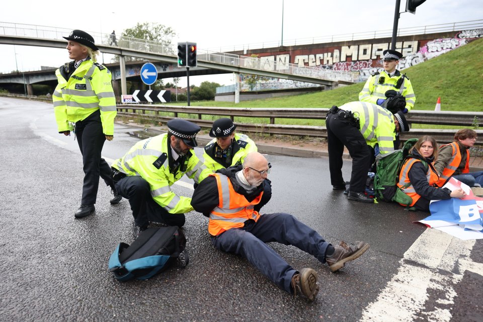 A protestor being arrested on the M1 at the junction with the North Circular at Staples Corner in north London