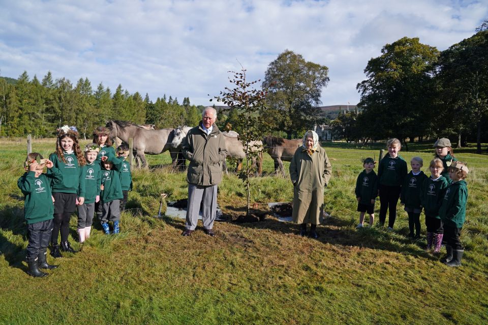 The Queen pictured with Prince Charles at Balmoral along with children from the nearby Crathie primary school