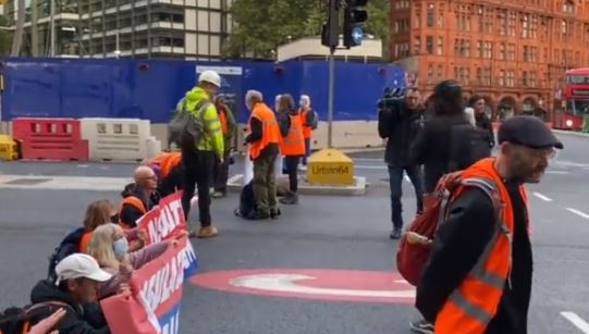 The gormless activists stared straight ahead as they sat across an exit